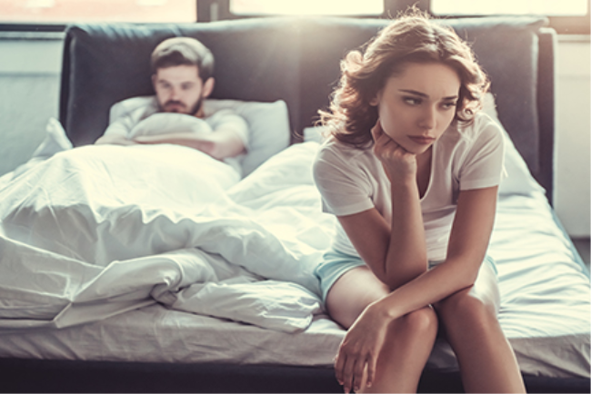 גבר ואישה מרוחקים על המיטה בשל בעיות בתפקוד המיני